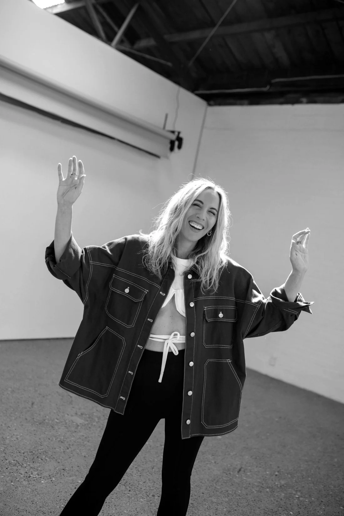 Amy Shaw raising her arms, photographed in black and white