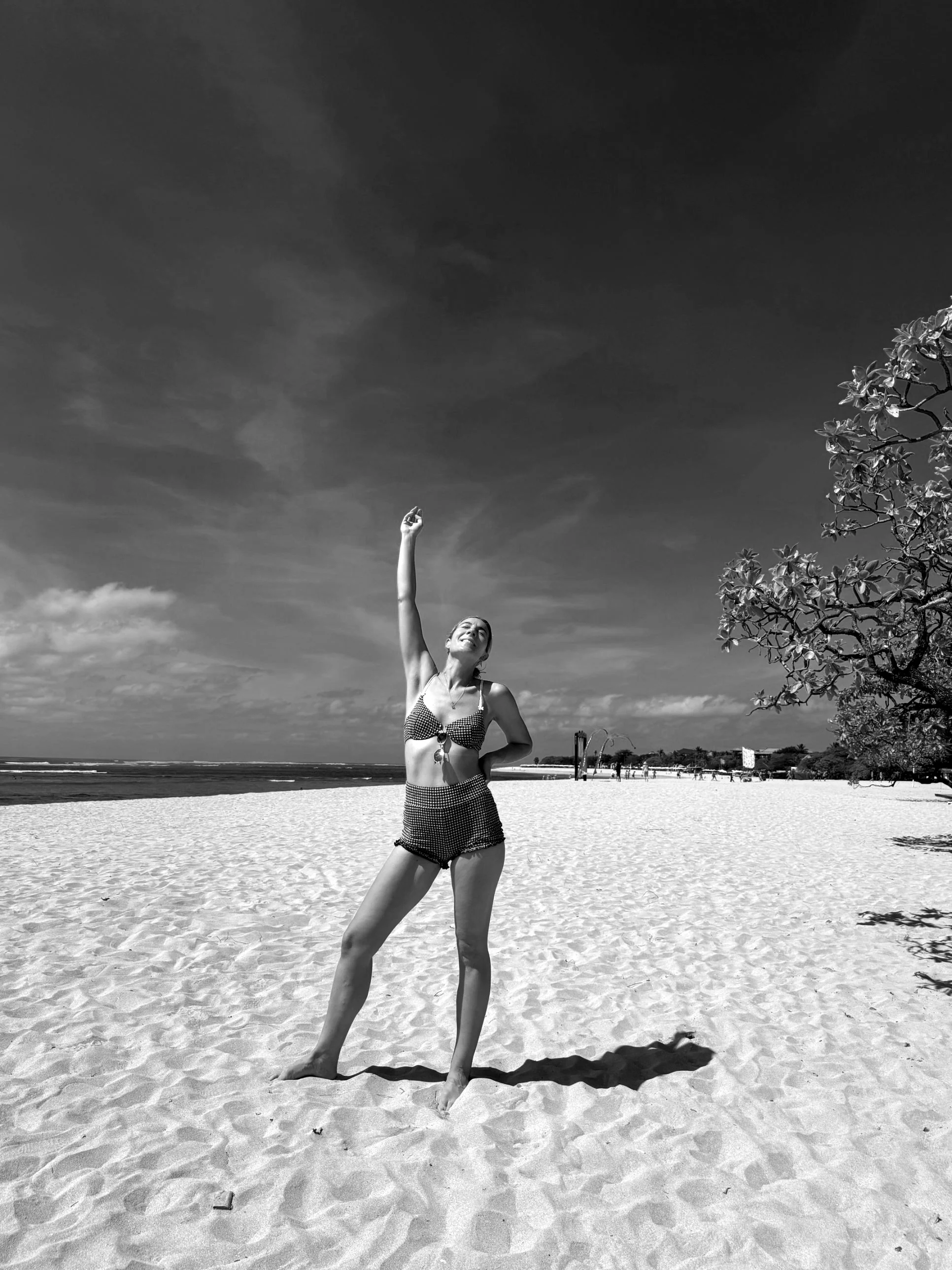 Amy with her arms outstretched on the coast